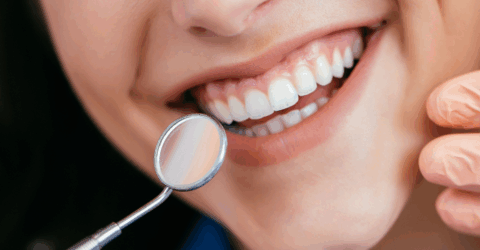 noia somrient després d'una neteja dental professional al dentista